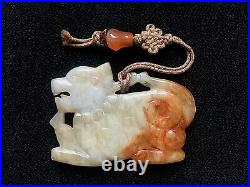 A Chinese celadon and russet jade pendant, 19th/20th century hand carved Foo Dog
